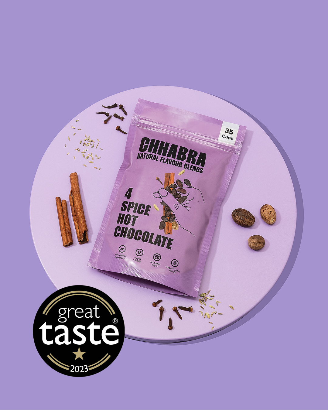 Chhabra 4 Spice Hot Chocolate package on a purple plate with cinnamon sticks and raisins, featuring the Great Taste award logo.
